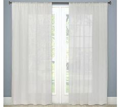 a white curtain hanging on the side of a window