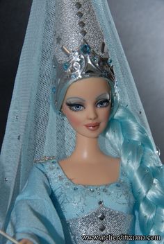 a doll wearing a blue dress and tiara with long braids on her head