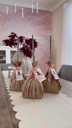 three bags sitting on top of a wooden table in front of a pink painted wall