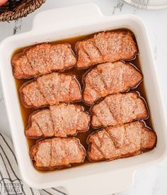 meatloaf with sauce in a white casserole dish on a marble countertop