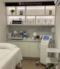 a room with a bed, desk and shelves filled with beauty products on the wall