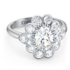 an engagement ring with a flower shaped center surrounded by round brilliant cut diamonds and engraved on the side