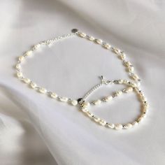 For the true pearl lover, this set of two luxury pieces of jewelry, consisting of a necklace and bracelet, is an absolute must-have. Made of silver stainless steel and freshwater pearls, these jewelry are timeless and elegant in design. The chain has a length of 30cm and the bracelet is 15.5cm long. Both jewelry have a 5cm extension, so they can also be worn looser for a perfect fit. The combination of the silver-colored stainless steel and the freshwater pearls give this jewelry a luxurious loo Single Strand Baroque Pearl Bracelet As Gift, Adjustable Pearl Jewelry Sets As Gift, Silver Baroque Pearl Bracelets As A Gift, Adjustable Pearl Jewelry Sets For Gift, Silver Baroque Pearl Bracelet With Pearl Chain, Silver Baroque Pearl Bracelet Gift, Sterling Silver Pearl Bracelet As Gift, Silver Pearl Jewelry Sets For Gifts, Pearl White Jewelry Sets With Pearl Chain For Gifts