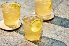 two glasses filled with lemonade sitting on top of a table next to each other