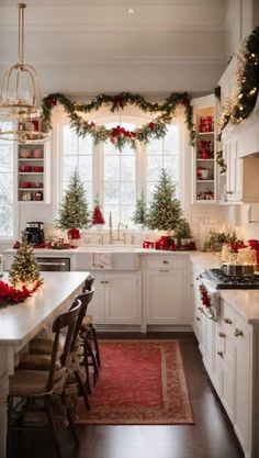 a kitchen decorated for christmas with garland and lights