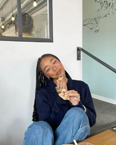 a woman sitting on the floor eating food