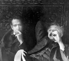 an old black and white photo of two people sitting down with their hands in their mouths