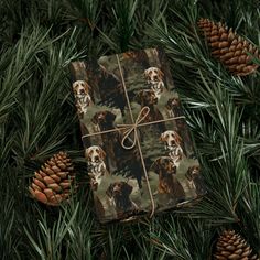 a present wrapped in brown paper with dogs on it and pine cones around it, all tied together