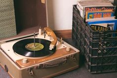 an old record player sitting on top of a suitcase