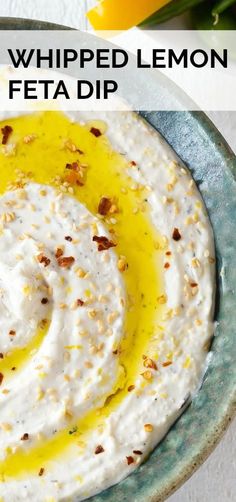 a bowl filled with whipped lemon and feta dip on top of a white table