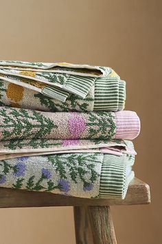 three folded towels sitting on top of a wooden chair