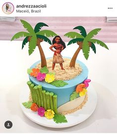 there is a cake decorated with a woman and two palm trees on the top of it