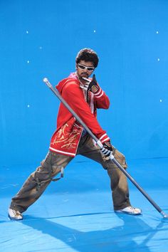 a man in red jacket and sunglasses holding a baseball bat on blue ground with stars behind him