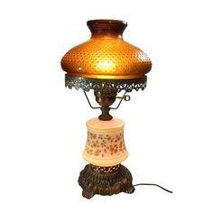 an old fashioned lamp with a yellow glass shade on it's top and base