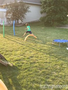 a young boy is jumping in the air to catch a frisbee while another person watches