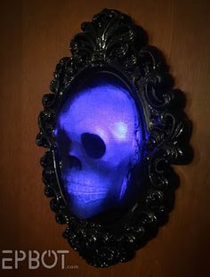 a blue skull in a black frame hanging on a wall