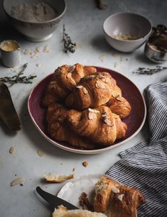 croissants are piled up on a plate