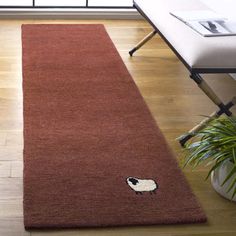 a red rug with a black and white cat on it in front of a window