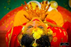 a woman with yellow flowers on her head and hands behind her head, covered in hendi