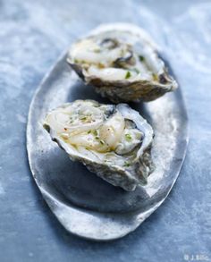 two oysters are on a silver plate