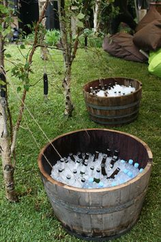 two wooden barrels filled with water sitting on the grass