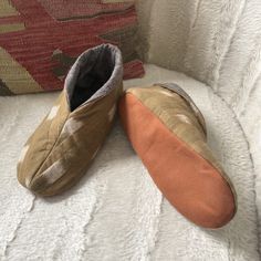 two slippers sitting on top of a white couch