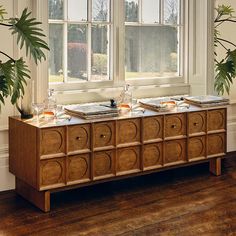 the sideboard is made out of wood and has two trays on it