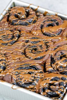 a pan filled with chocolate doughnuts covered in caramel drizzled