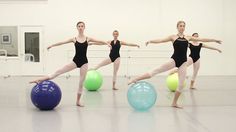 four ballerinas in black leotards are balancing on balls