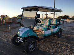 a blue and white golf cart parked on the beach