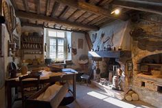 an old fashioned kitchen with stone fireplace and wood stove top oven in the middle of it