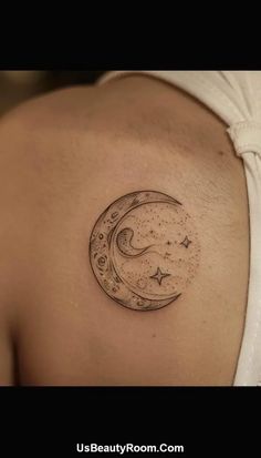 a woman's shoulder with a crescent and stars tattoo on it