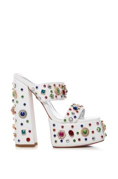 The AZALEA WANG Breeze Embellished Chunky Sandal In White is made from a faux leather upper and features an open squared almond toe silhouette, dual foot bands, a mule design, a cushioned, reflective insole, a towering, chunky heel, a slip-on fit, and a platform sole. Complete with rhinestone and gem embellishments along the bands, heel, and sole.  Psst, this style runs small. We recommend sizing up half a size.   (All measurements approximate, measured from a women’s size 7.5):  - Faux leather upper - Open squared almond toe - Chunky heel - Platform sole - 6.5” heel height - 2.25” sole height - Imported  Product ID: 333473 White Heel Boots, Block Heel Mules, Chunky Platform Sandals, Jeweled Shoes, Miss Lola, Azalea Wang, Sandals Outfit, Statement Shoe, Platform Block Heels