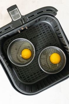 two fried eggs in a waffle style pan on top of each other with one yellow egg between them