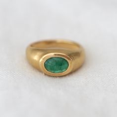 Emerald cabochon set in 20K solid yellow gold signet ring on white background Luxury Yellow Gold Emerald Ring With Oval Cabochon, Heirloom Yellow Gold Emerald Cabochon Ring, Classic Gold Emerald Cabochon Ring, Timeless Gold Dome Ring With Cabochon, Gold Emerald Cabochon Ring For Formal Occasions, Timeless Yellow Gold Signet Ring With Emerald, Timeless Yellow Gold Emerald Signet Ring, Timeless Yellow Gold Dome Ring With Cabochon, Timeless Gold Round Emerald Ring