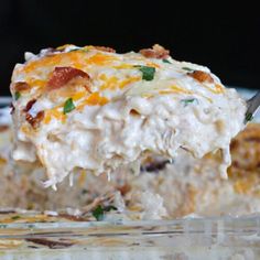 a close up of food on a fork in a glass dish with other dishes and utensils