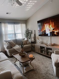 a living room filled with furniture and a flat screen tv mounted to the wall over a fireplace