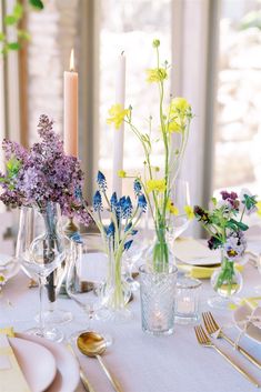 the table is set with flowers and candles