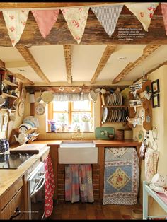 a kitchen filled with lots of counter top space and hanging dishes on the wall above it