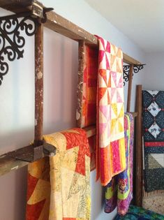 several quilts are hanging on the wall next to each other