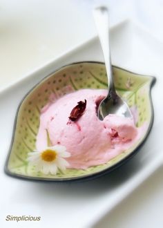 a spoon is in a bowl with ice cream and daisies on the rims