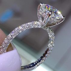 a close up of a diamond ring on someone's finger