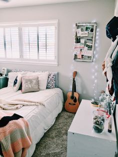 a bed room with a neatly made bed and a guitar