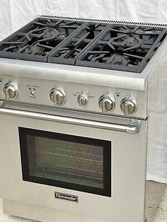 a stainless steel stove with four burners and two oven doors on the front side