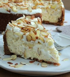 a piece of cheesecake on a white plate with a fork in front of it