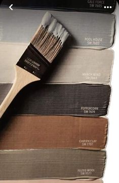 a paint brush sitting on top of some different color swatches and colors for the walls