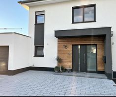 a modern house with two garages on the side and one door open to let in light