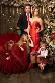 a family posing for a christmas photo in front of a christmas tree