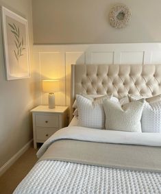 a bed with white sheets and pillows in a bedroom