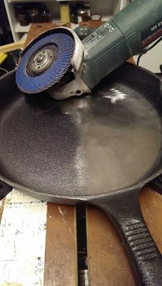 a sanding pan with a grinder on top of it sitting on a wooden table